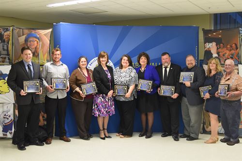 Hall of Achievement winners pose in a group with their plaques